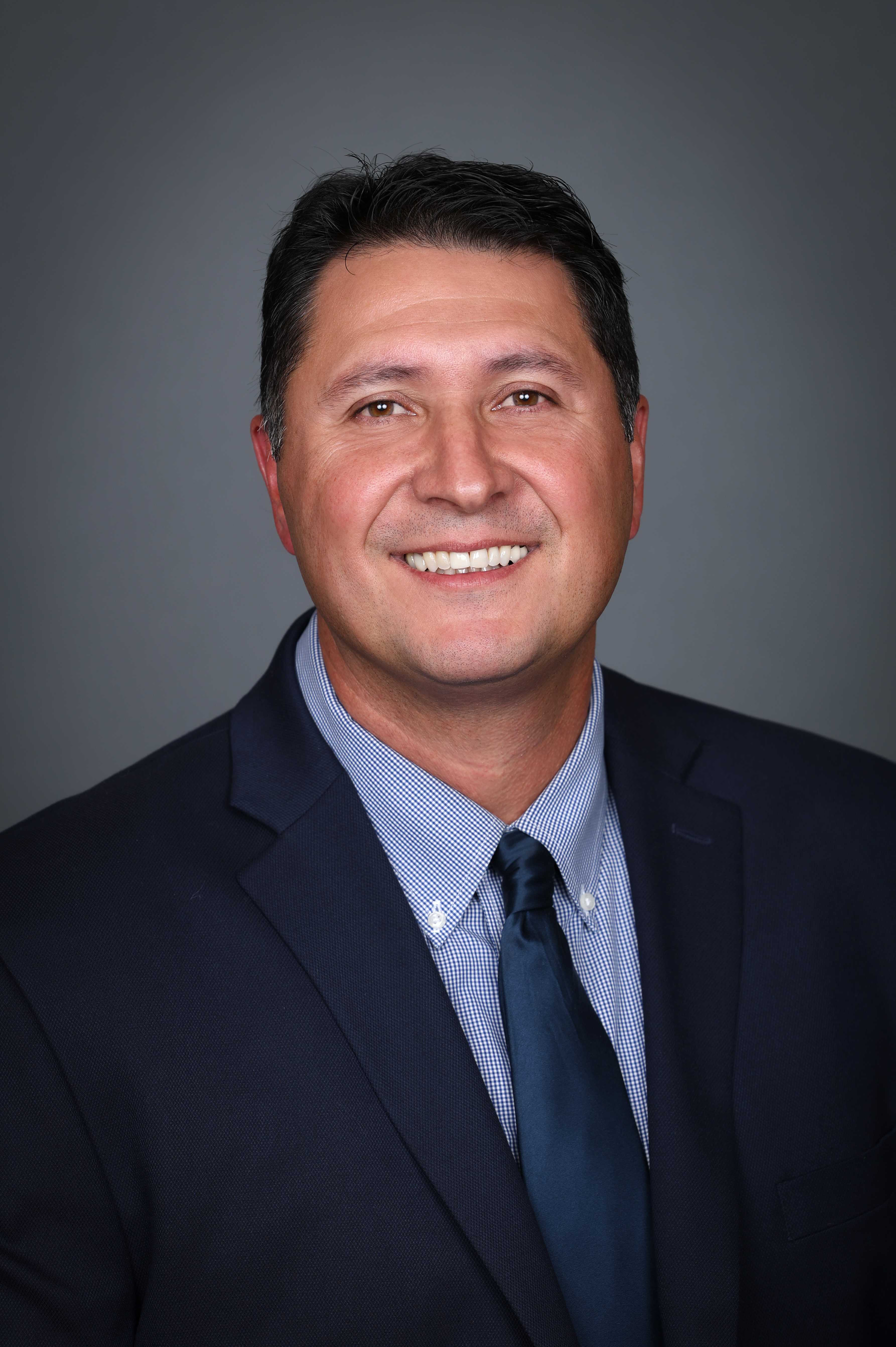 photo of George Mendoza in a blue shirt, tie and jacket